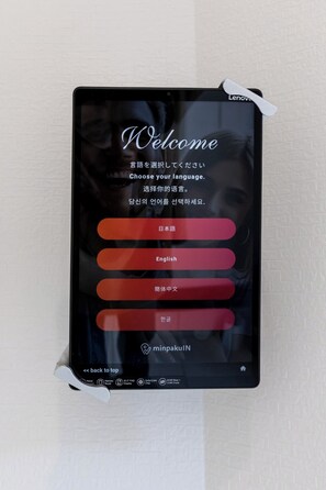 A Lenovo tablet with a welcome screen displaying language selection options. - Hotel Kiki (Osaka)