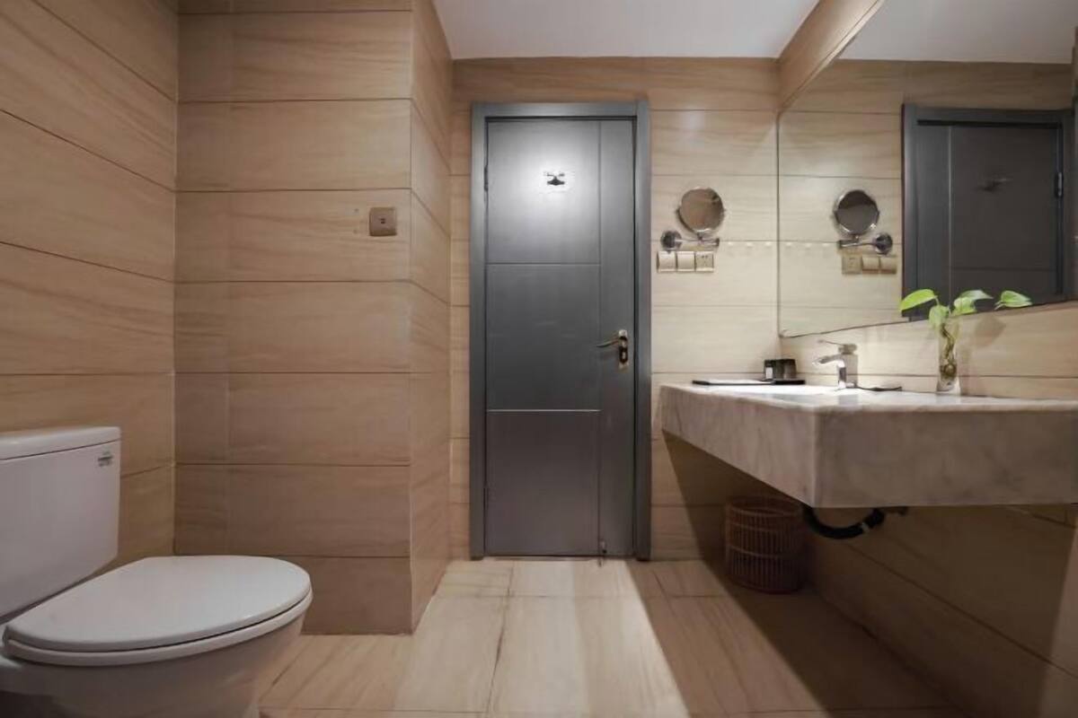 Un baño moderno con inodoro, lavamanos con espejo y una puerta.