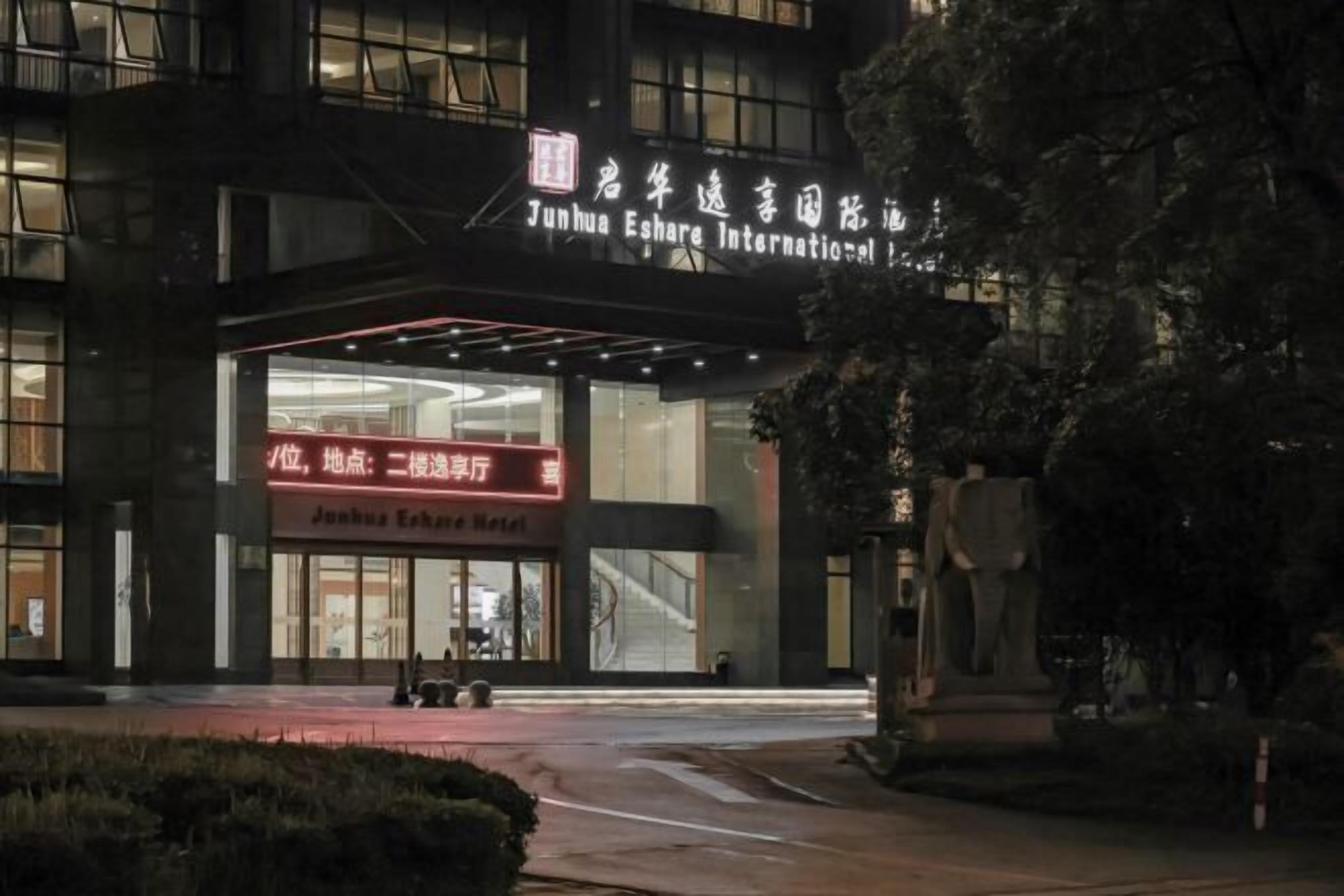 Das Hotel Junhua Eshare International mit einem markanten Eingang und Beschilderung.