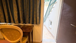 A bathroom with a toilet, a wooden chair, and a patterned curtain. - Cupido Suite by Ca-sa Check (Venice)
