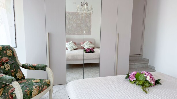 Ein Schlafzimmer mit Bett, Stuhl, Kleiderschrank und einer Treppe.