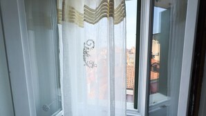 Ein Fenster mit einem verzierten Vorhang mit floralem Muster.