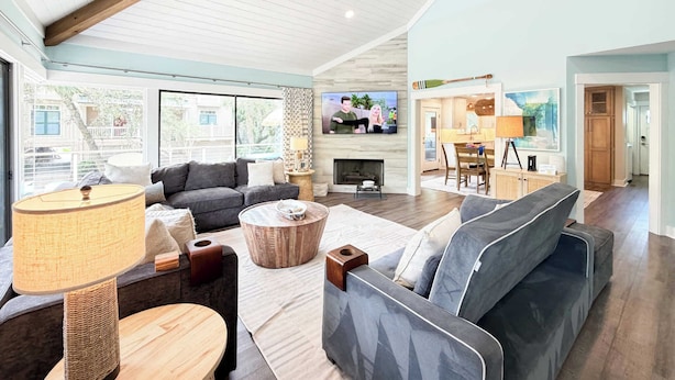 Un salón amplio con chimenea, televisor y comedor.