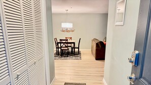 A hallway with a dining area, a sofa, and a chandelier. - Pet Friendly Beach Villa 2 Bed 2 Bath #7105 TreeTops (Hilton Head Island)