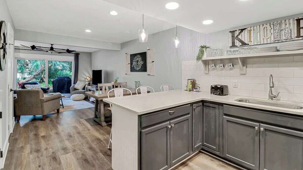 Cocina moderna con una isla central, armarios oscuros y un cartel que dice 'KITCHEN'.