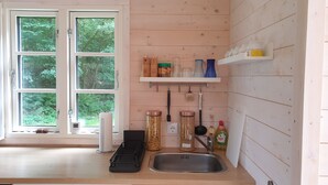 Une cuisine au décor intérieur en bois, avec un évier et des bocaux remplis de pâtes.