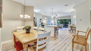 Una cocina amplia con una isla central, una mesa de comedor de madera y sillas.