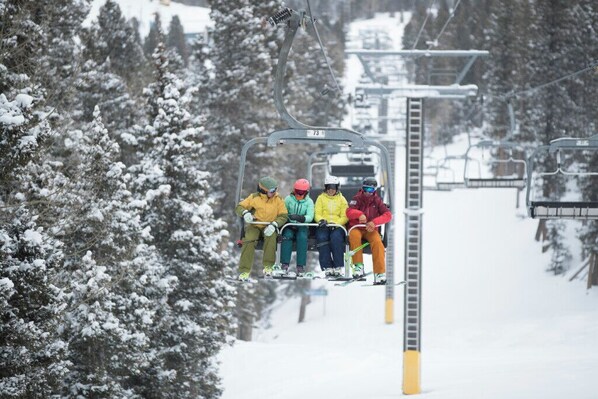 A ski lift with passengers in colorful winter clothing.