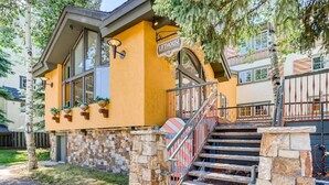 A building with a yellow facade, a sign reading "LIFEHOUSE," and a staircase leading to the entrance. - Lover's Landing | Walk to Gondola | Rooftop Hot Tub #026194 (Vail)