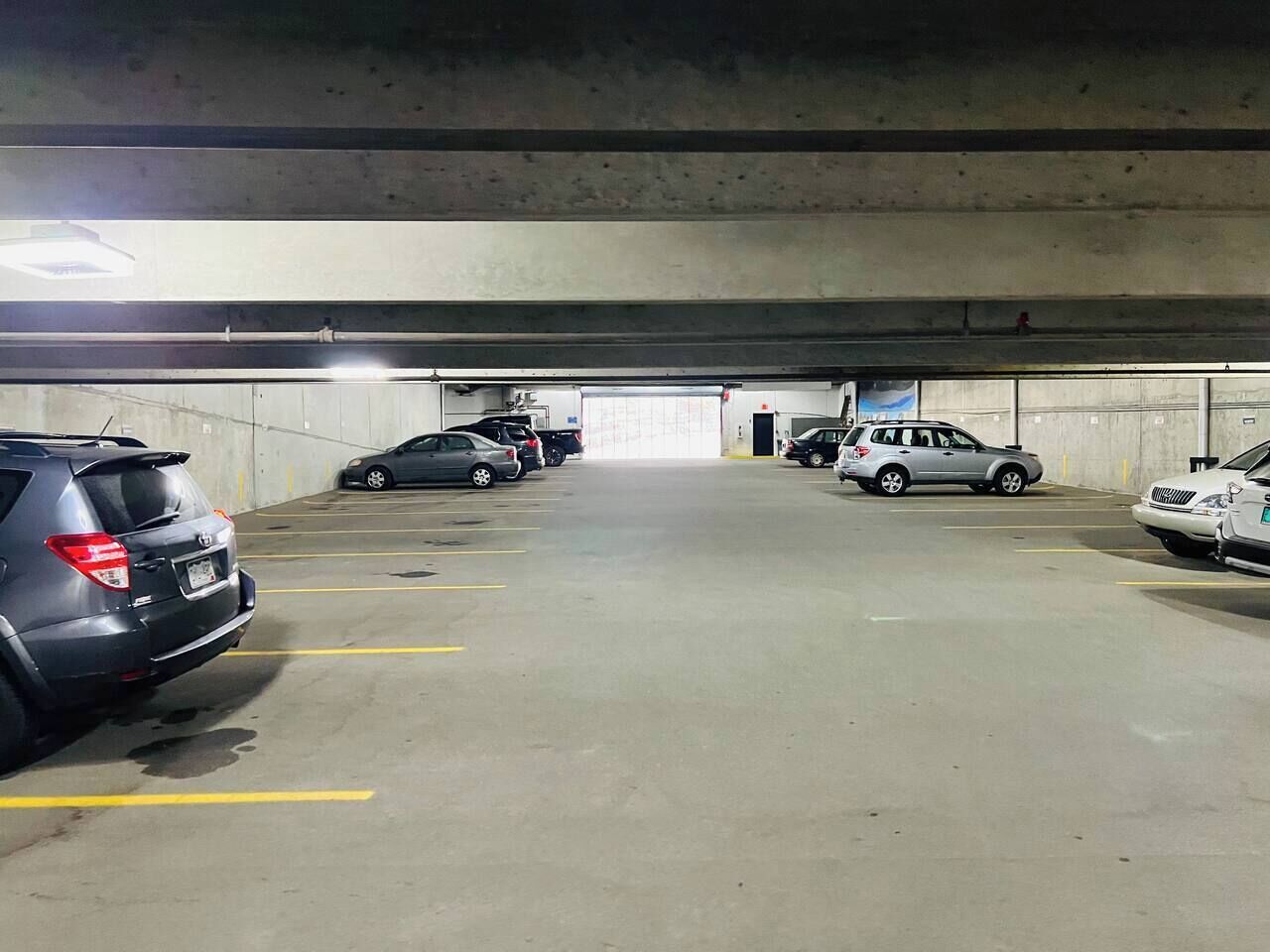 An underground parking garage with multiple cars parked in designated spaces.