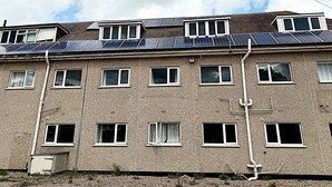 A multi-story building with a flat roof, multiple windows, and visible utility pipes. - Simplystay Lincoln Road (Skegness)