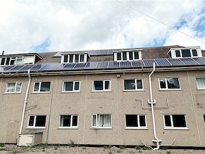 A multi-story building with a flat roof, multiple windows, and visible utility pipes. - Simplystay Lincoln Road (Skegness)