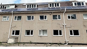 A multi-story building with a flat roof, multiple windows, and visible utility pipes. - Simplystay Lincoln Road (Skegness)