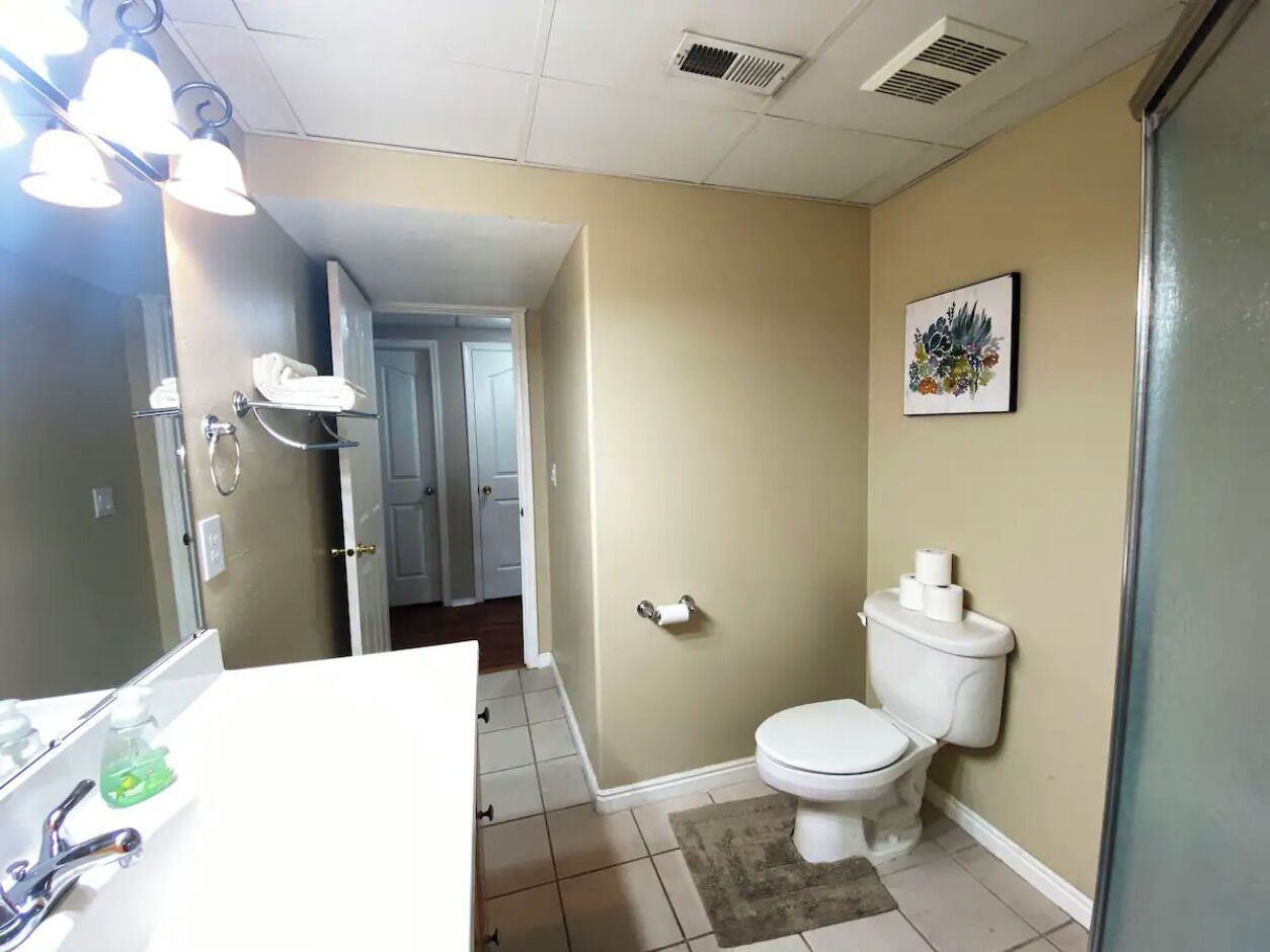 A bathroom with a white sink, a toilet, and a shower area.