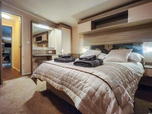 A hotel room with a bed, a bedside table, a mirror, and a wardrobe. - 2 bedroom accommodation in Hamstead (Hamstead)