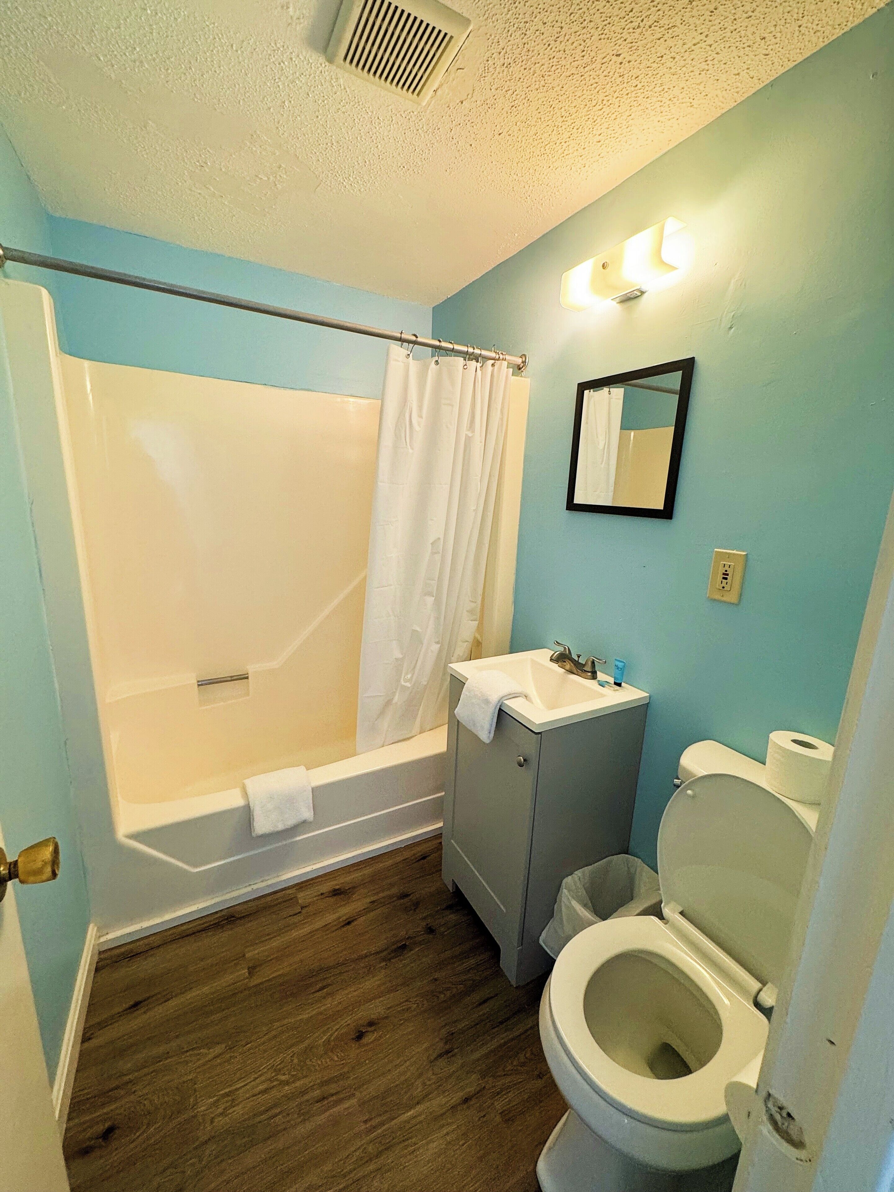 Un baño con bañera, lavamanos e inodoro.