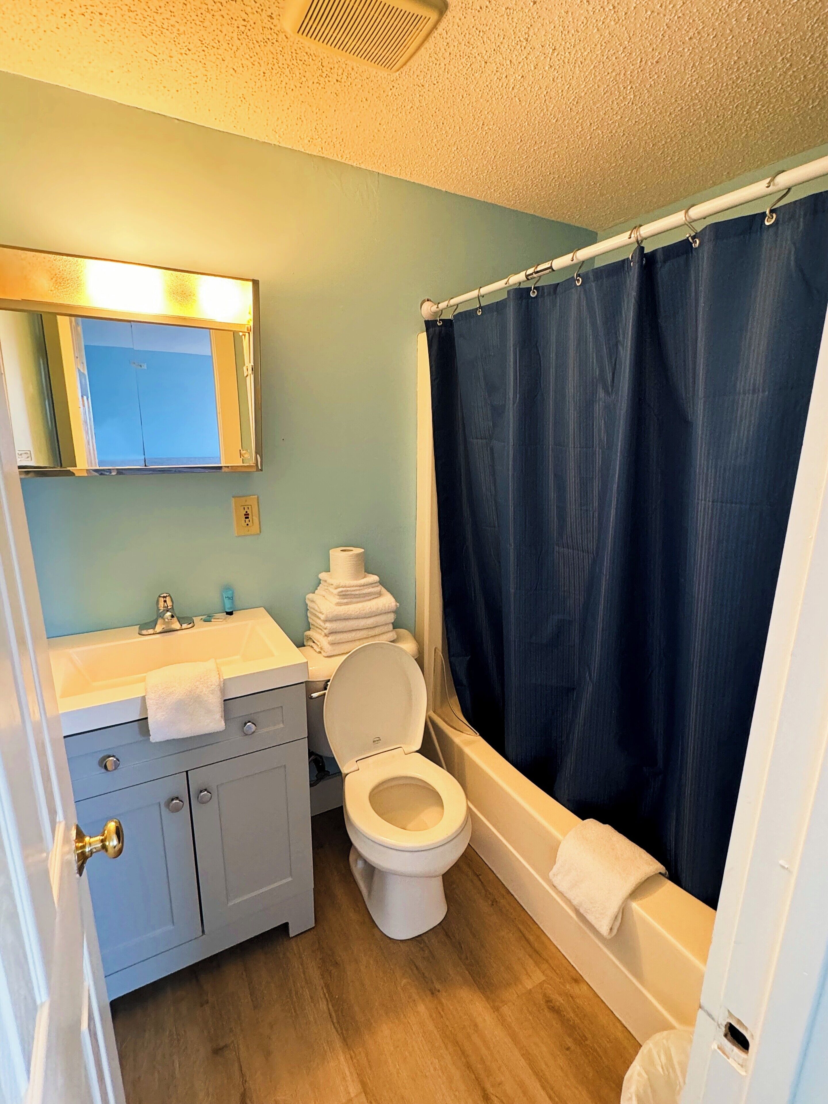 A bathroom with a toilet, sink, and bathtub.