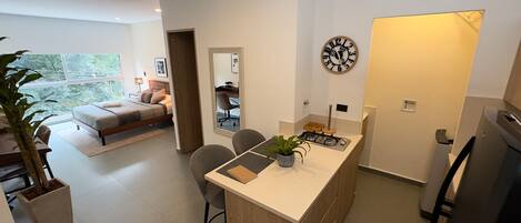 A modern apartment with a kitchen, dining area, and a bedroom with a view.