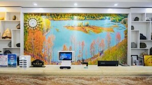A reception desk with a painting of a river and trees, a clock, and a digital display. - Qiyu Hotel (Burqin)