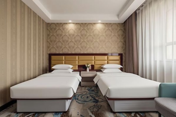 A hotel room with two beds, a headboard, a small table, and a window with curtains. - Qiyu Hotel (Burqin)