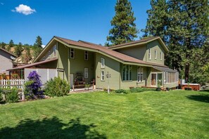 A two-story house with a covered porch, a fenced yard, and a well-maintained lawn. - Luxurious Lifestyle Just Minutes From Leavenworth (Leavenworth)