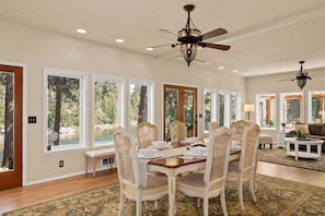 A dining area with a round table, white chairs, and a ceiling fan. - Luxurious Lifestyle Just Minutes From Leavenworth (Leavenworth)