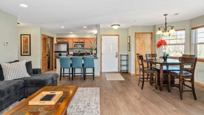 A modern living room with a sofa, coffee table, and dining area with chairs and a table. - Leavenworth Condo - 1BR w/ Jetted Tub + Pool (Leavenworth)