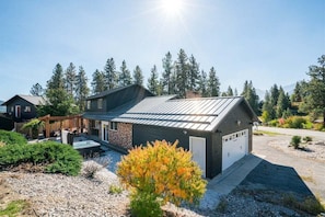 A modern house with a garage, a covered patio, and a gravel driveway.