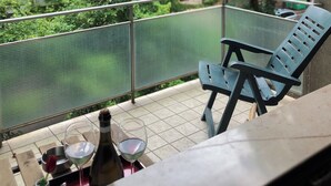 A balcony with a chair and a table, a bottle, and a glass of wine. - Cosy, spacious, bright and central. Three double bedrooms (Venezia)
