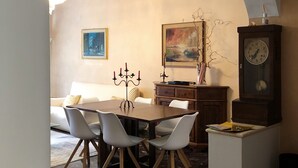 A dining area with a marble floor, a dining table with chairs, a sofa, a candelabra, and a clock on a cabinet. - Cosy, spacious, bright and central. Three double bedrooms (Venezia)