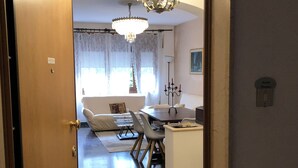 A room with a dining area, a chandelier, and a tiled floor. - Cosy, spacious, bright and central. Three double bedrooms (Venezia)