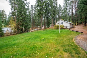 A house surrounded by a forested area with a well-maintained lawn. - Escape and Reconnect at this Woodsy Haven (Leavenworth)