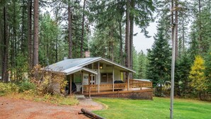 A cabin with a porch, surrounded by tall trees. - Woodsy Leavenworth Hideaway w/ Hot Tub + Fireplace, Near Trails (Leavenworth)