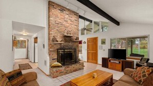 A living room with a fireplace, a television, and a sofa. - Woodsy Leavenworth Hideaway w/ Hot Tub + Fireplace, Near Trails (Leavenworth)