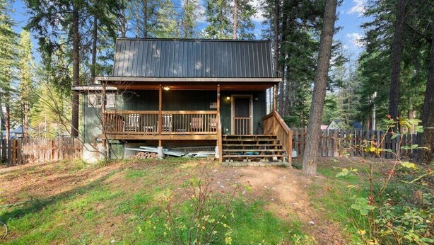 A cabin with a porch, a front door, and a small staircase leading up to the entrance.