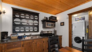 A kitchen with wooden cabinets, a built-in microwave, a sink, and a stove.