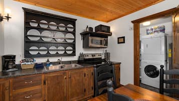 A kitchen with wooden cabinets, a built-in microwave, a sink, and a stove.