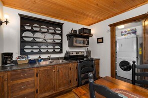A kitchen with wooden cabinets, a built-in microwave, a sink, and a stove.