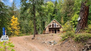 A cabin in a forest with a dirt path leading to it. - Pet-Friendly Lake Wenatchee Cabin + Deck (Leavenworth)