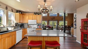 Une cuisine spacieuse avec des meubles en bois, un îlot central et un lustre.