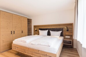 Ein Schlafzimmer mit einem hölzernen Bettgestell, einem großen Kleiderschrank und einem Nachttisch mit Lampe.