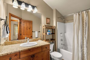 A bathroom with a sink, mirror, shower, and toilet. - Pet-friendly, Two-Level Condo Downtown (Leavenworth)