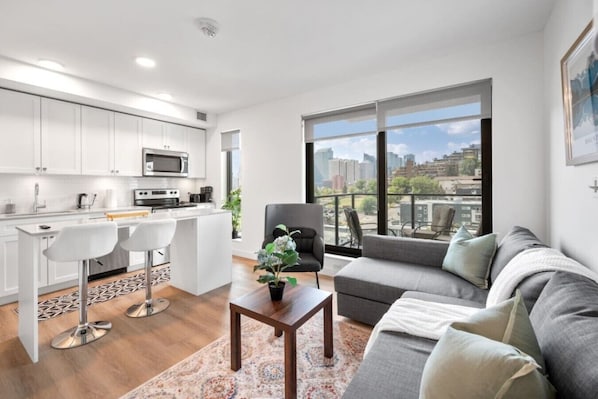 Een modern appartement met keuken, eetgedeelte en woonkamer met uitzicht over de stad.