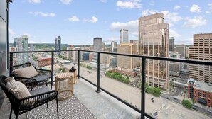 A balcony with a view of a cityscape, including high-rise buildings and a clear sky. - DT Views |UG Park | Mins to Saddledome | Gym (Calgary)