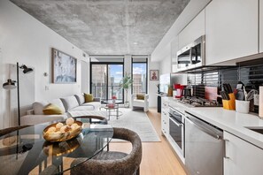 A modern apartment with a kitchen, dining area, and living room.
