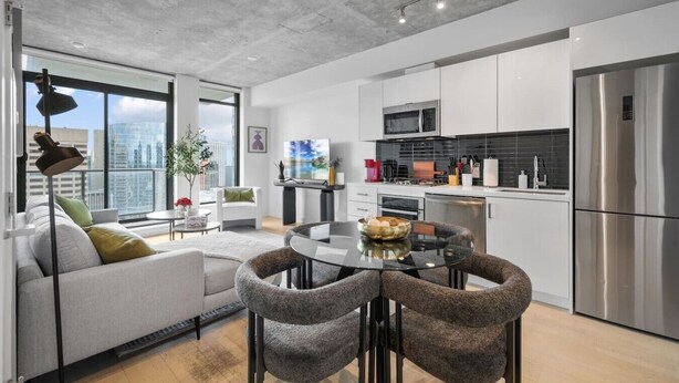 A modern apartment with a dining area, kitchen, and living space. - DT Views |UG Park | Mins to Saddledome | Gym (Calgary)