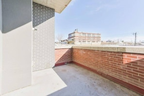 Parte de um edifício com parede de tijolos e estrutura de concreto.