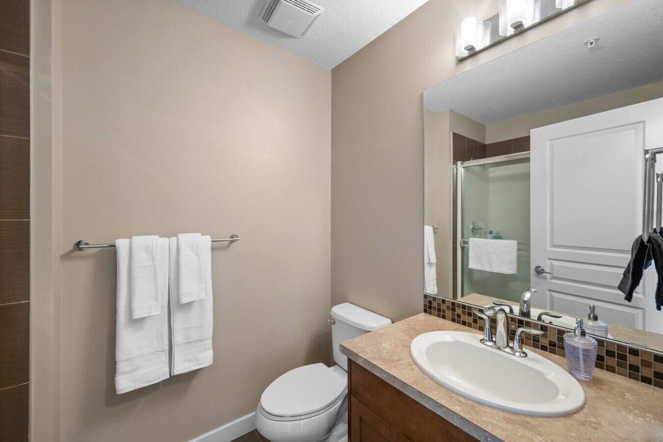 A bathroom with a toilet, sink, and towel rack.