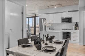 Uma cozinha moderna com armários brancos, micro-ondas e fogão.
