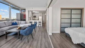 Un appartement moderne comprenant un espace de vie, une cuisine et un balcon avec vue sur la ville.